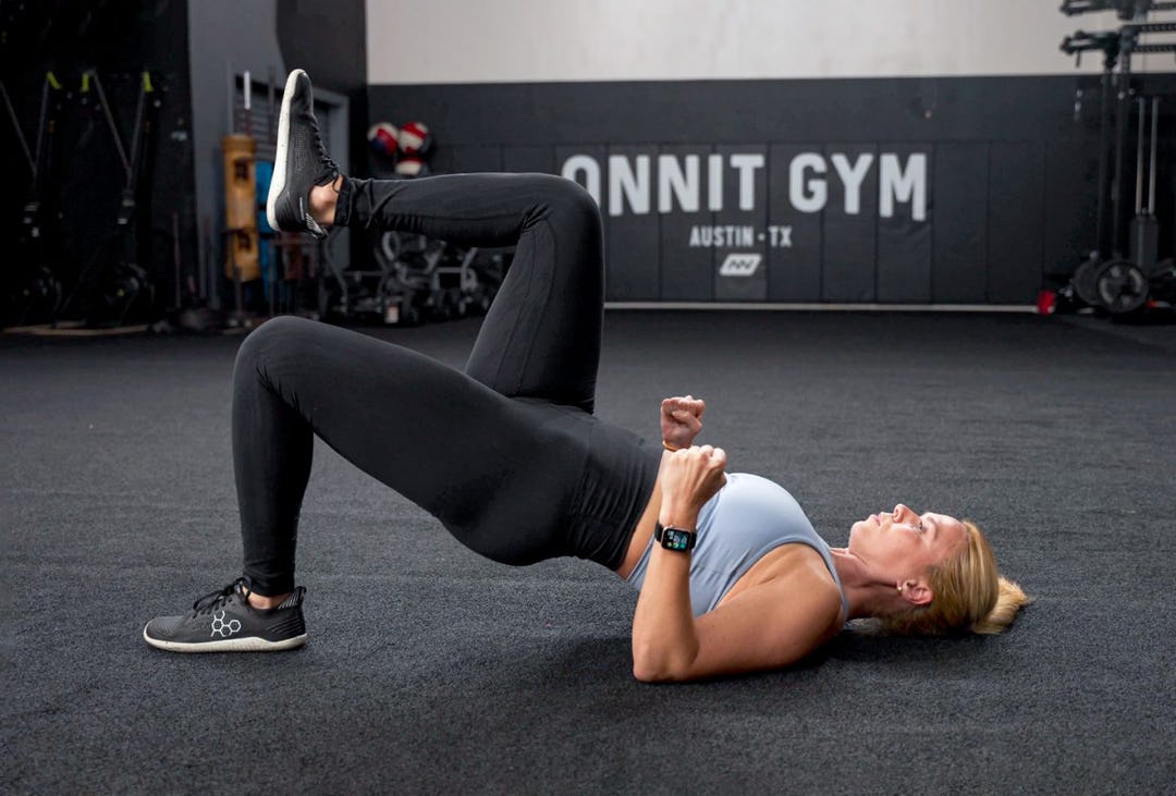 Woman performs single-leg glute bridge.